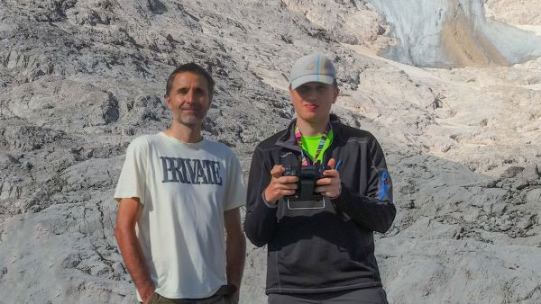 Maciej in a white T-shirt and Irek in a hat photographed on the Hallstaetter glacier foreground. 